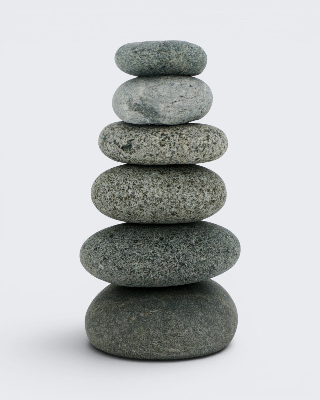 Front view of handcrafted cairn vase with six stacked gray beach stones on a white background, 7 inch natural stone bud vase
