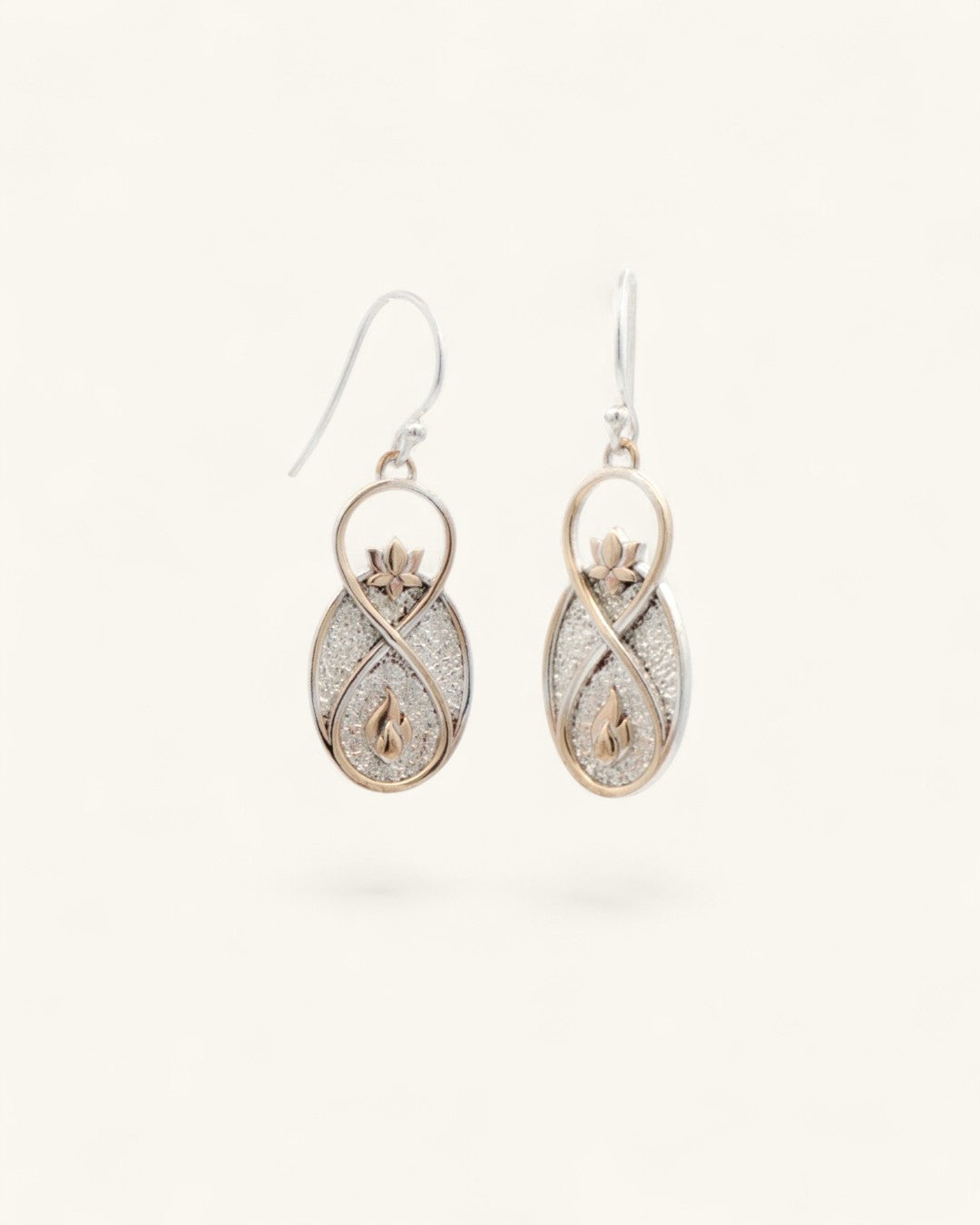 Infinite Lotus drop earrings angled view on white background, showing depth of the silver glitter oval body with bronze framing