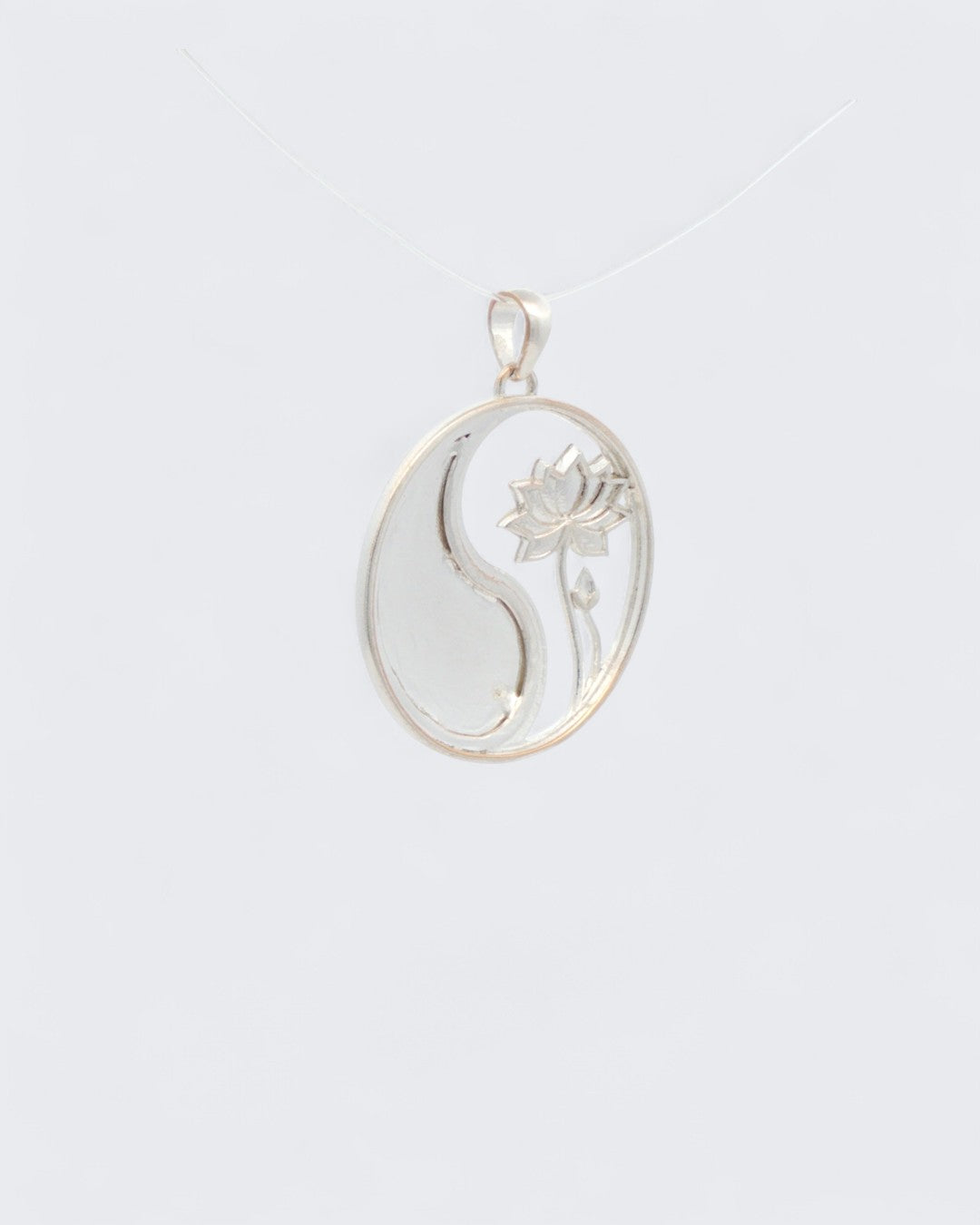 Yin yang lotus pendant back view in uniform silver showing mirrored yin yang symbol with lotus flower relief on the right side
