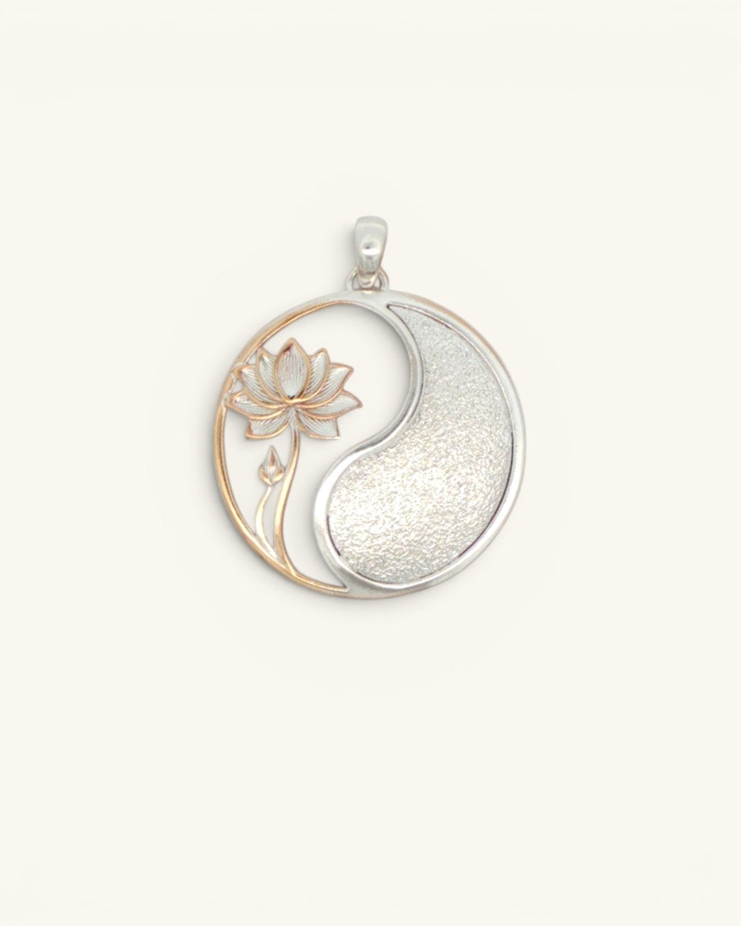 Yin yang lotus pendant with rose gold lotus cutout on left and textured silver fill on right, front view on cream background