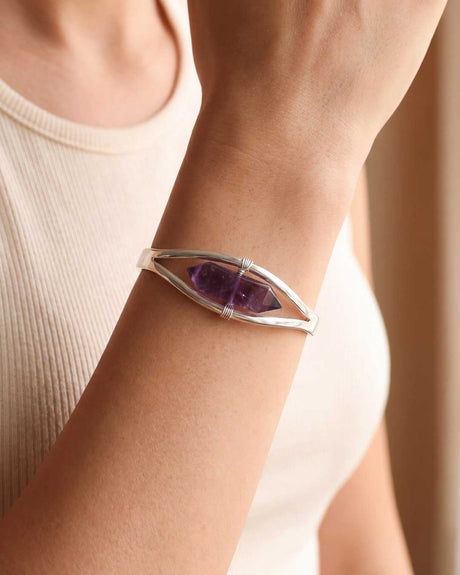 Woman wearing silver amethyst point cuff bracelet on her wrist with a casual white tank top