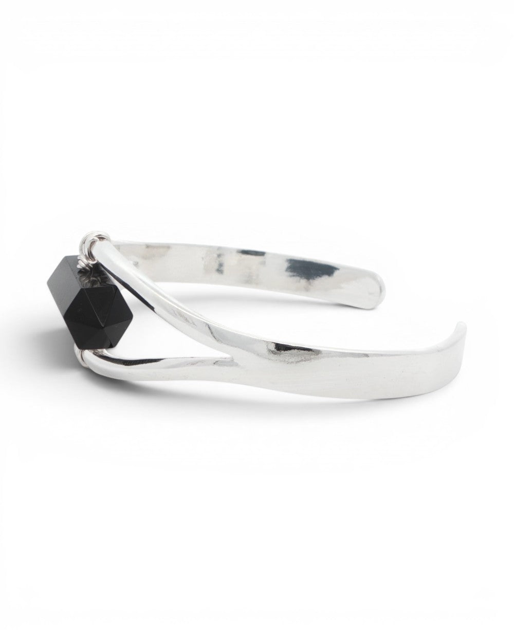 Side profile of silver black onyx cuff bracelet showing the open curved band and wire-wrapped stone