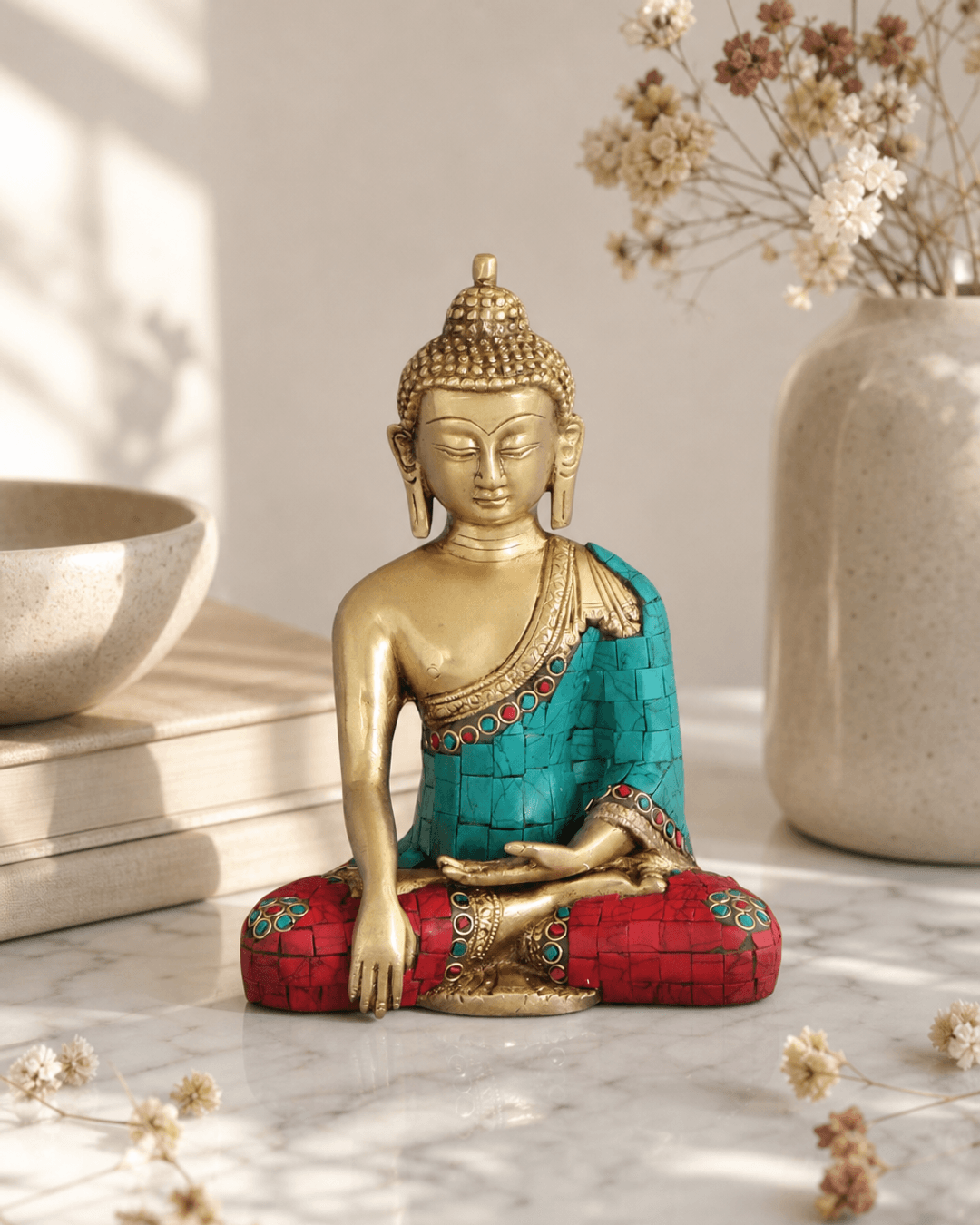 Brass Shakyamuni Buddha statue with colorful painted detailing displayed on white marble surface