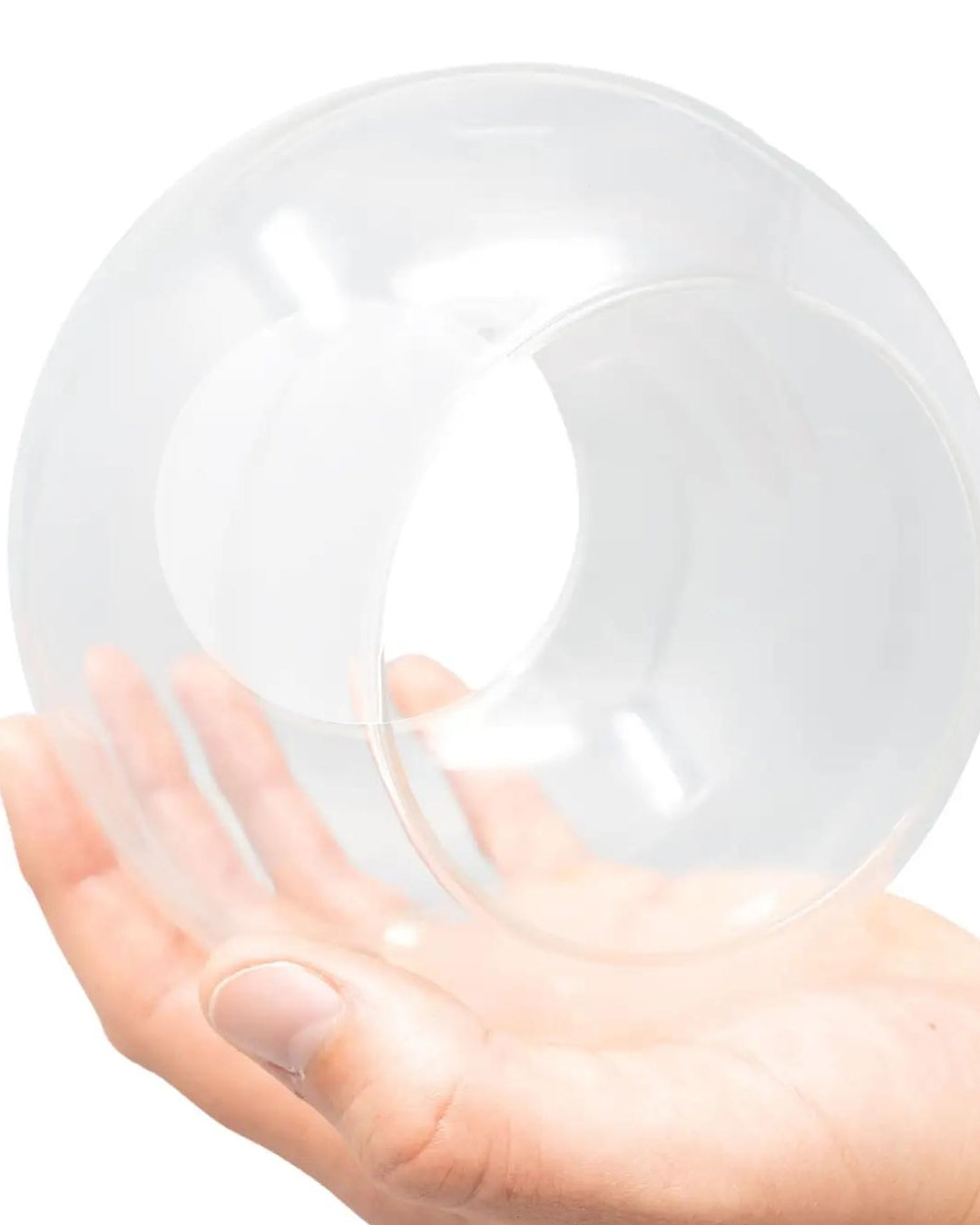 Empty round glass terrarium globe with open end held in an open palm, showing the large size and clear glass construction