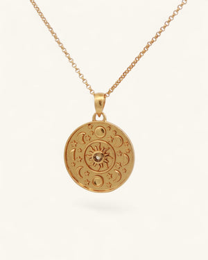 Celestial Sun and Moon Citrine Pendant hanging on a gold cable chain, angled view showing engraved sun and moon face