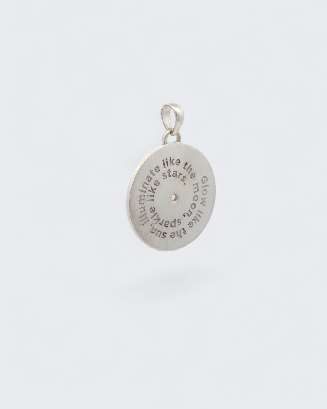 Back of Celestial Sun Moon Phases Pendant showing engraved spiral text reading Glow like the sun, illuminate like the moon, sparkle like stars