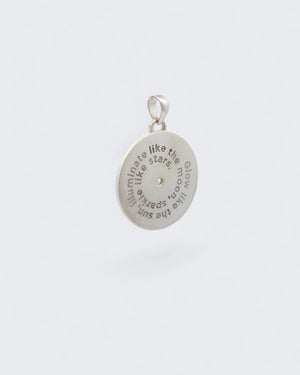 Back of Celestial Sun Moon Phases Pendant showing engraved spiral text reading Glow like the sun, illuminate like the moon, sparkle like stars