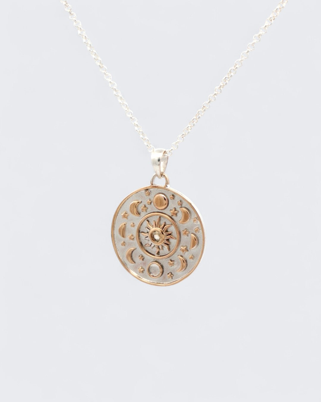 Celestial Sun Moon Phases Pendant hanging on silver chain, showing full front face with bronze moon phases and sun motif