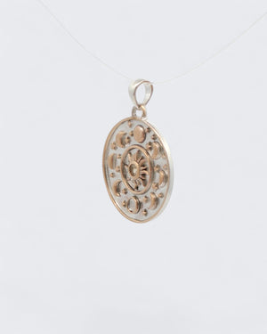Celestial Sun Moon Phases Pendant viewed from the side on clear cord, revealing the disc edge thickness and bronze rim detail