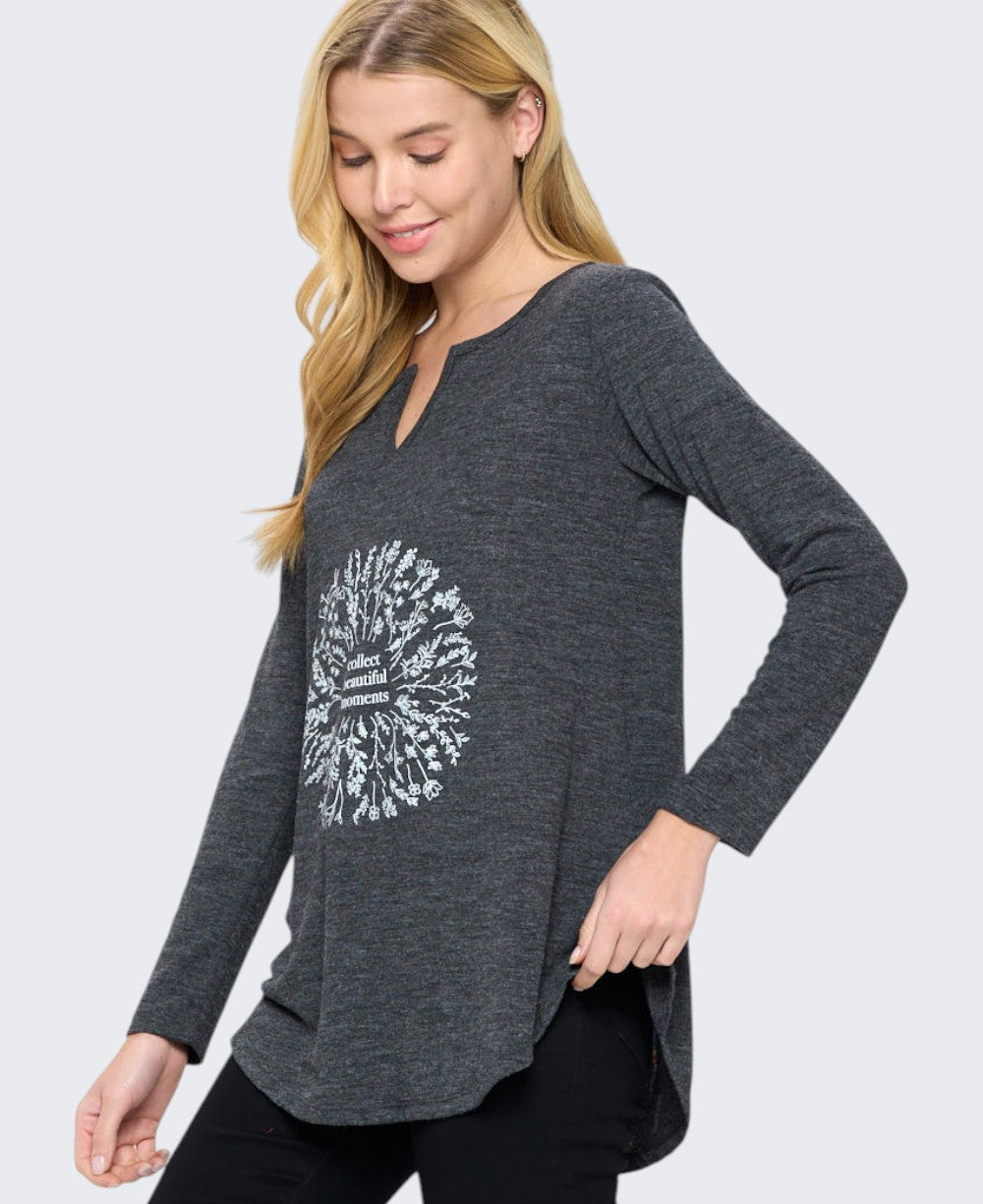 Side angle view of charcoal grey long sleeve tunic top showing split neckline, curved hem, and white floral wreath chest graphic