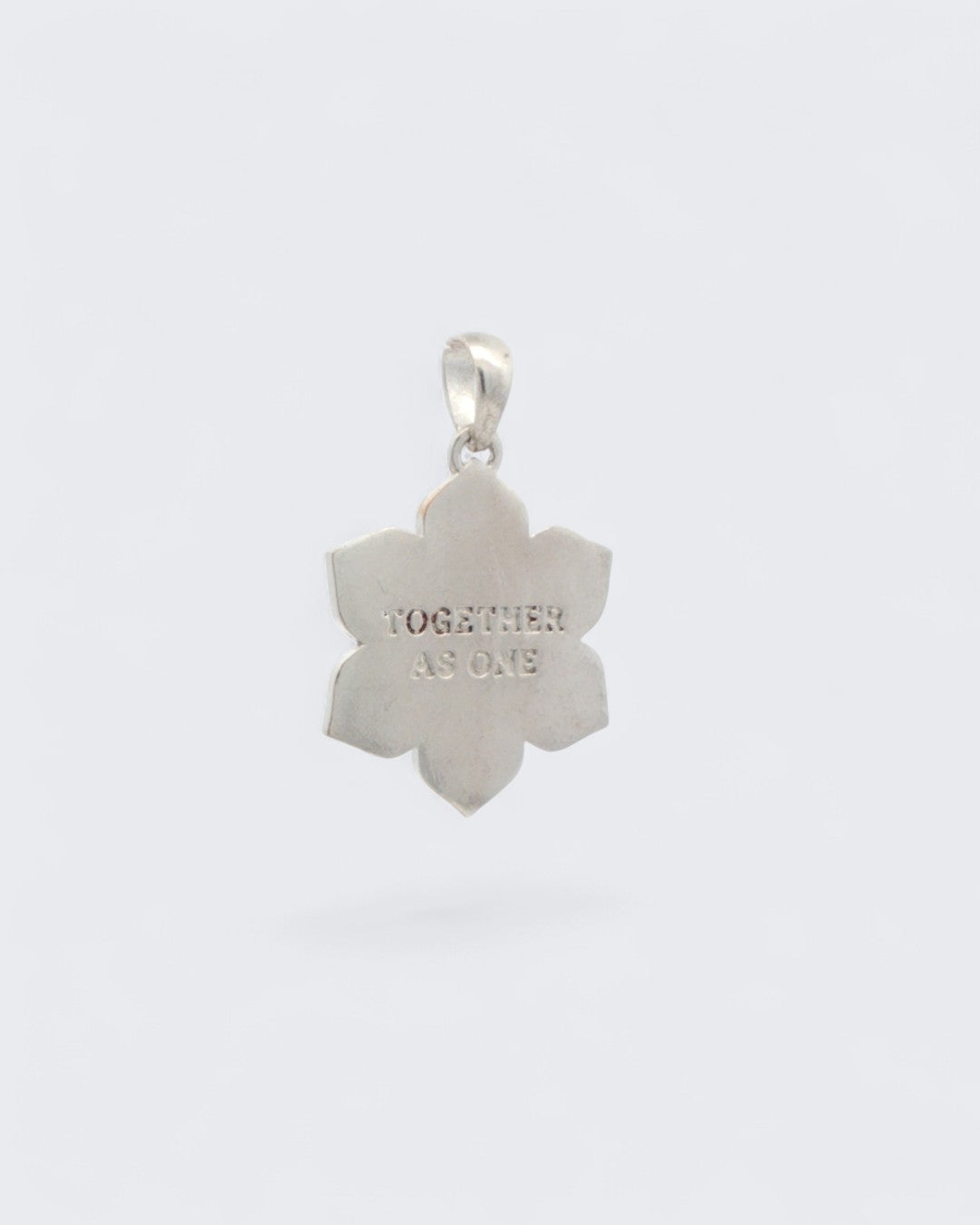 Back of Coexist Harmony Lotus Pendant showing smooth silver-plated surface with TOGETHER AS ONE engraved in the center