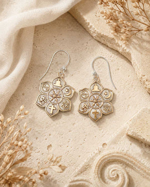 Coexist Harmony Earrings displayed on sandy stone surface alongside dried botanicals and white linen, styled flat lay