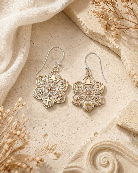 Coexist Harmony Earrings displayed on sandy stone surface alongside dried botanicals and white linen, styled flat lay