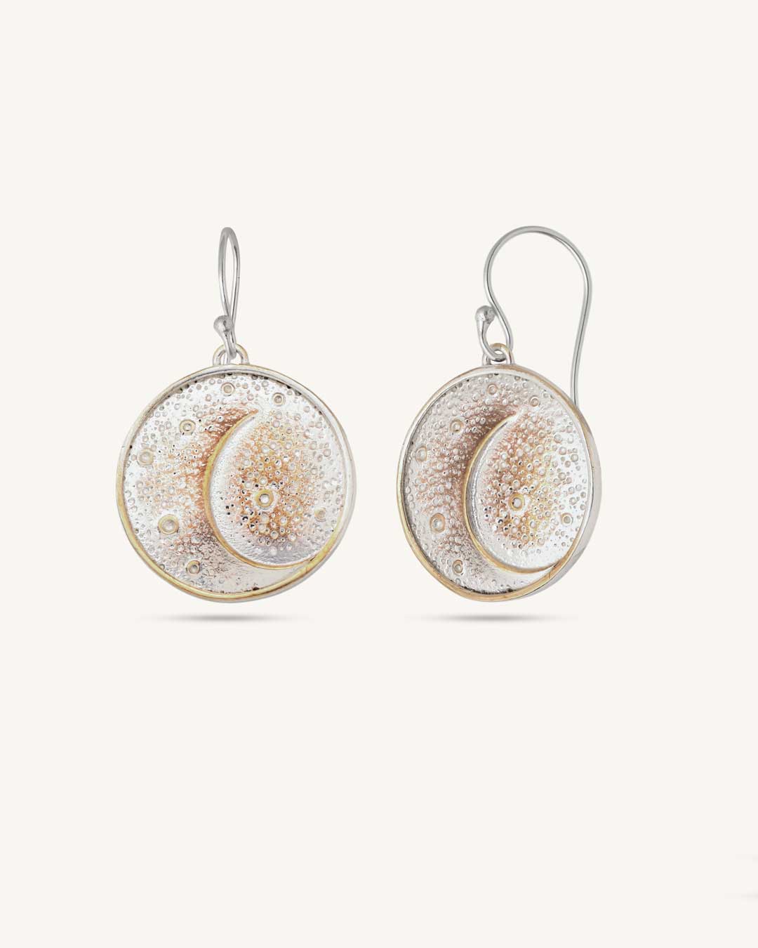 Crescent moon disc earrings in silver-plated bronze, angled side view showing dimensional raised crescent and textured disc face