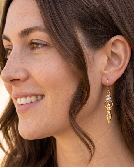 Model wearing Sacred Feminine Goddess Earring with moonstone and gold-plated goddess figure pendant, close-up side profile
