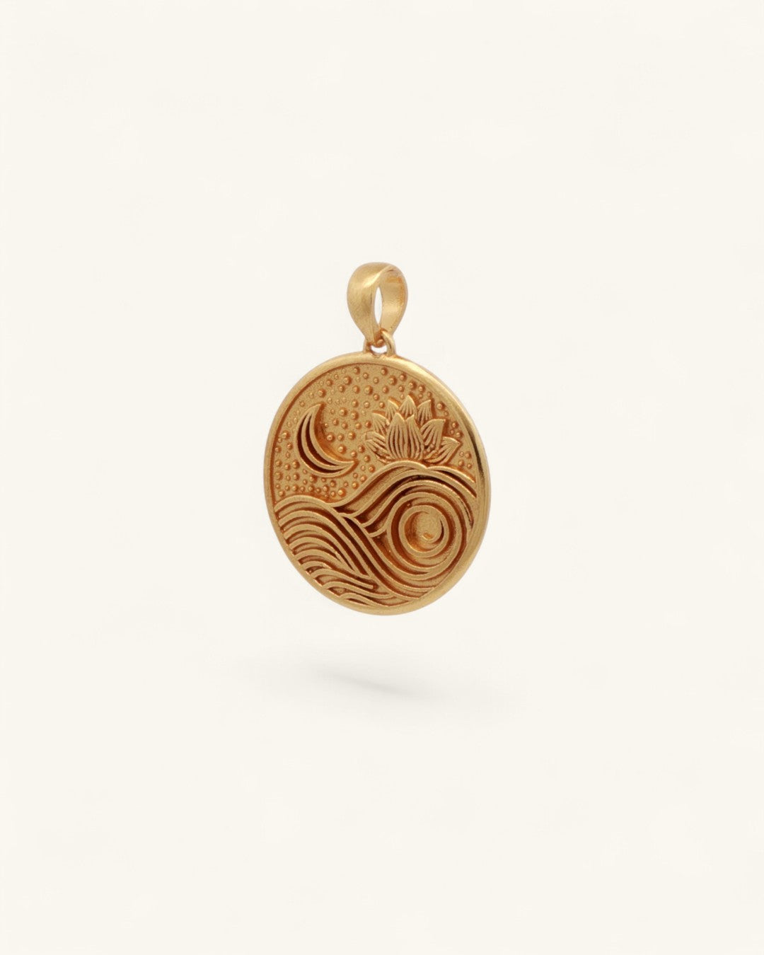 Gold plated brass lotus moon and wave pendant shown at a slight side angle, revealing engraved relief depth and bail