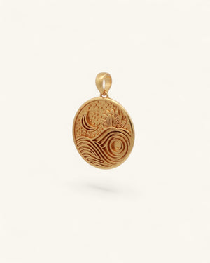 Gold plated brass lotus moon and wave pendant shown at a slight side angle, revealing engraved relief depth and bail