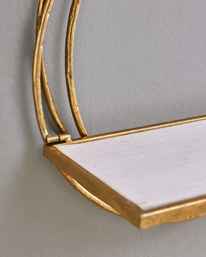Close-up detail of golden rings wall shelf showing layered antique gold metal frame and whitewash wood shelf ledge