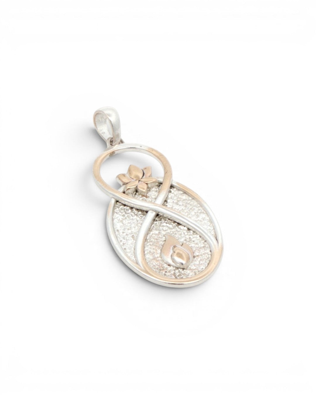 Infinite Lotus & Flame Pendant at a tilted angle on white background, showing the textured silver oval and gold-tone accents