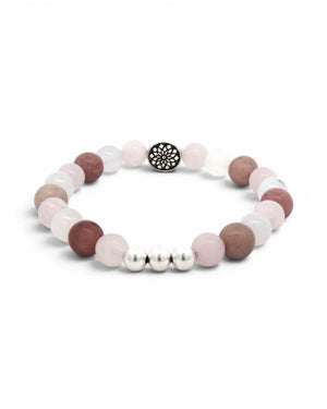 Mandala gemstone stretch bracelet angled side view on white, three silver accent beads at front, full ring of mixed pink gemstone beads