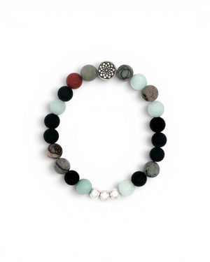 Mandala gemstone stretch bracelet laid flat, showing chalcedony, onyx, red jasper beads and silver mandala charm