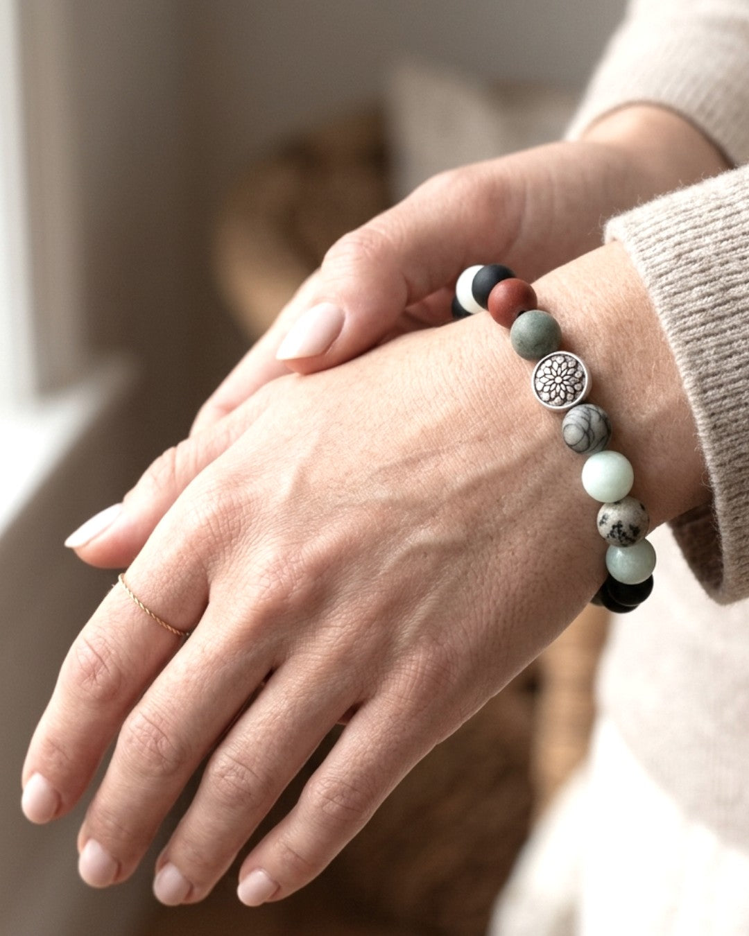 Mandala gemstone stretch bracelet worn on wrist, silver mandala charm visible with mixed gemstone beads