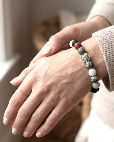 Mandala gemstone stretch bracelet worn on wrist, silver mandala charm visible with mixed gemstone beads