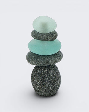 Single medium mini stacked stone cairn with alternating grey stones and teal sea glass pieces on a white background, front view