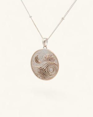 Moon wave lotus pendant hanging on a silver satellite chain at an angle, showing engraved moon and lotus detail