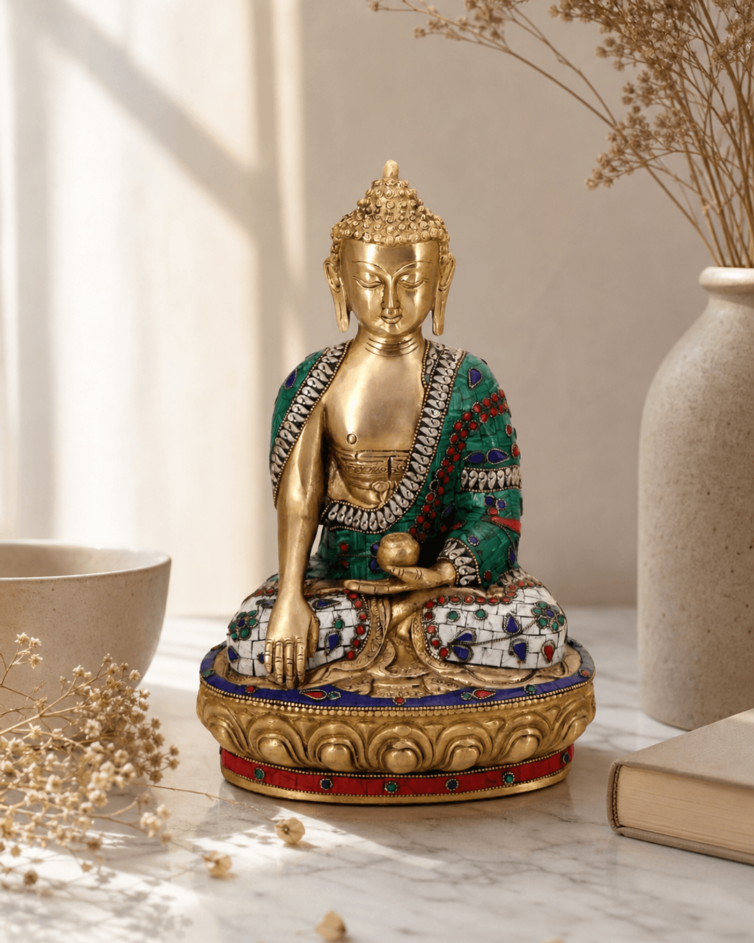 Brass Shakyamuni Buddha statue in earth touching pose with mosaic work detailing displayed on marble surface