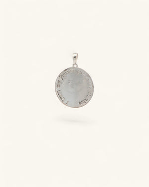 Back of silver crescent moon pendant showing engraved affirmation text circling the rim of the round disc