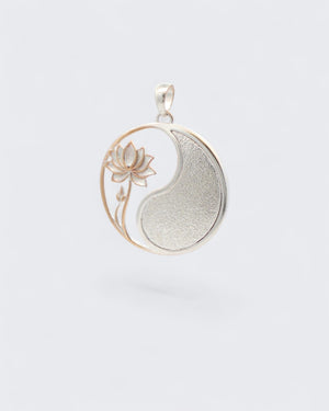 Yin yang lotus pendant tilted at an angle showing the rose gold lotus stem detail and the curved silver yang portion and bail