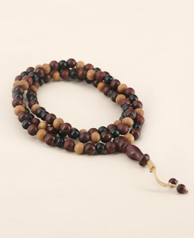 Elegant four wood types mala beads with adjustable knotted tassel, featuring 108 sandalwood, rosewood, ebony, and walnut wooden beads and 1 glass guru bead for meditation and mindfulness